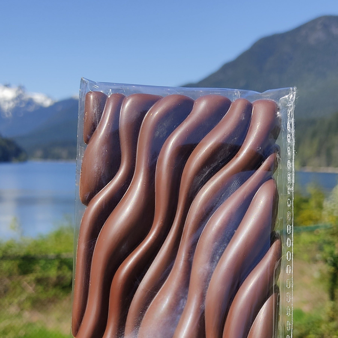 A handcrafted 46% dairy-free milk chocolate bar, wrapped in minimalist packaging, placed on a neutral background with a clean, artisanal look.